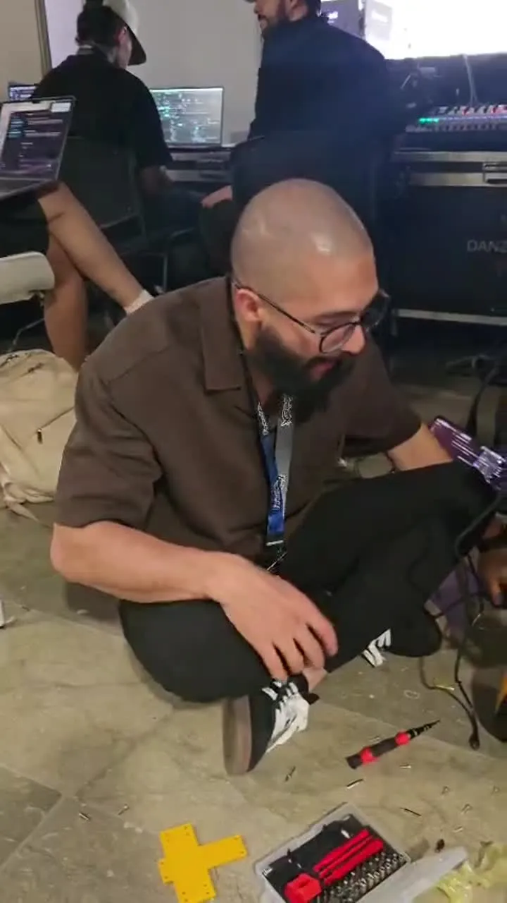 Jamilton Valkor soldando piezas del robot en el piso del laboratorio